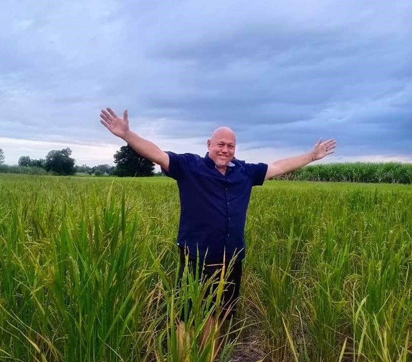 Terry standing among the rice fields at home in rural Thailand
